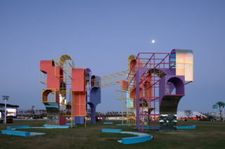 Two large playground-like structures connected via a yellow bridge
