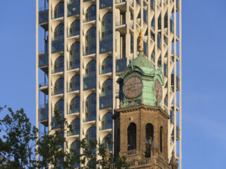 Façade of POST by ODA and Omnam Group behind the tower of Rotterdam’s former Central Post Office. Photo: Ossip van Duivenbode.