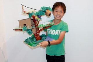 Child with treehouse model