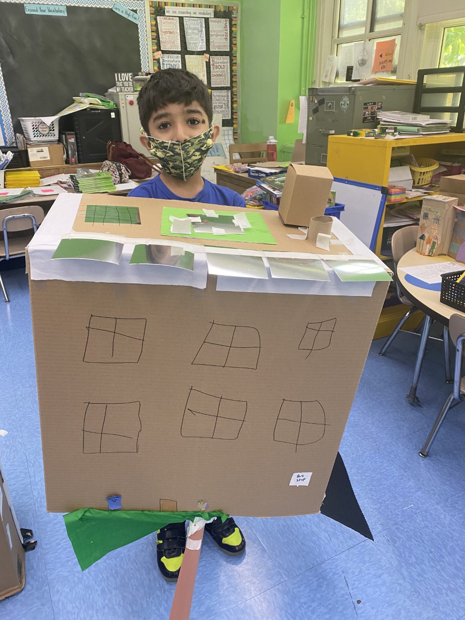 Photo of student holding up their green roof design.