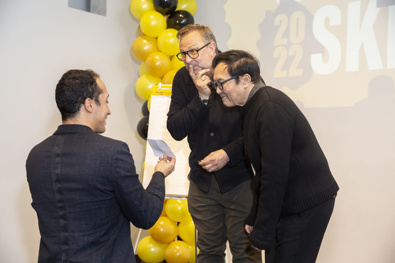 Honoree sketchers Matthew Bremer and Calvin Tsao consult one of the cue cards with emcee Jerome Haferd