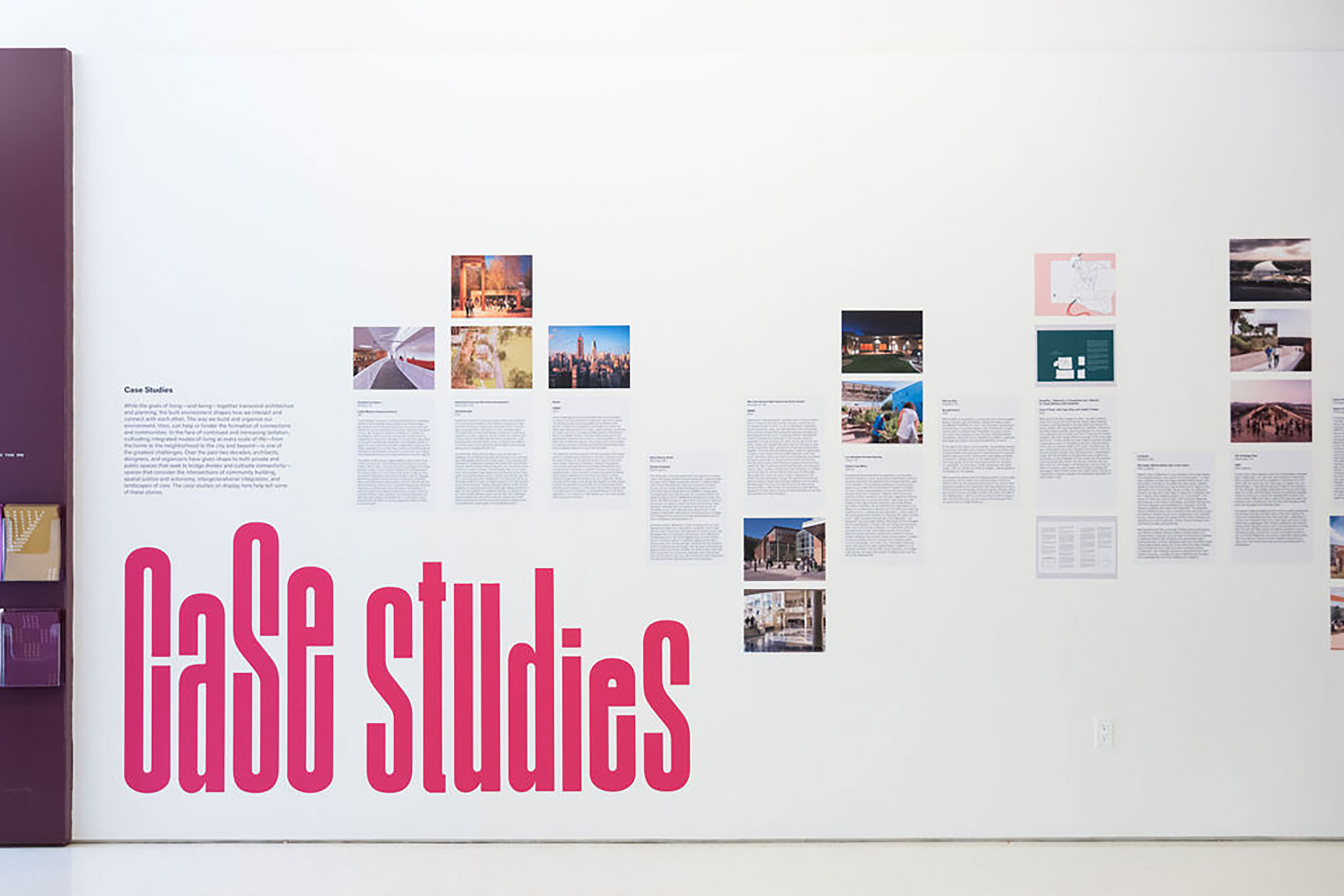 Installation view of a white gallery wall with images and text spanning across the middle of the wall horizontally.