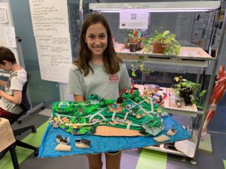 Student with model of landscaped waterfront and buildings