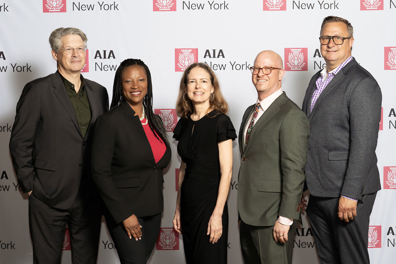 5 people arranged in front of a step-and-repeat with AIA New York logos