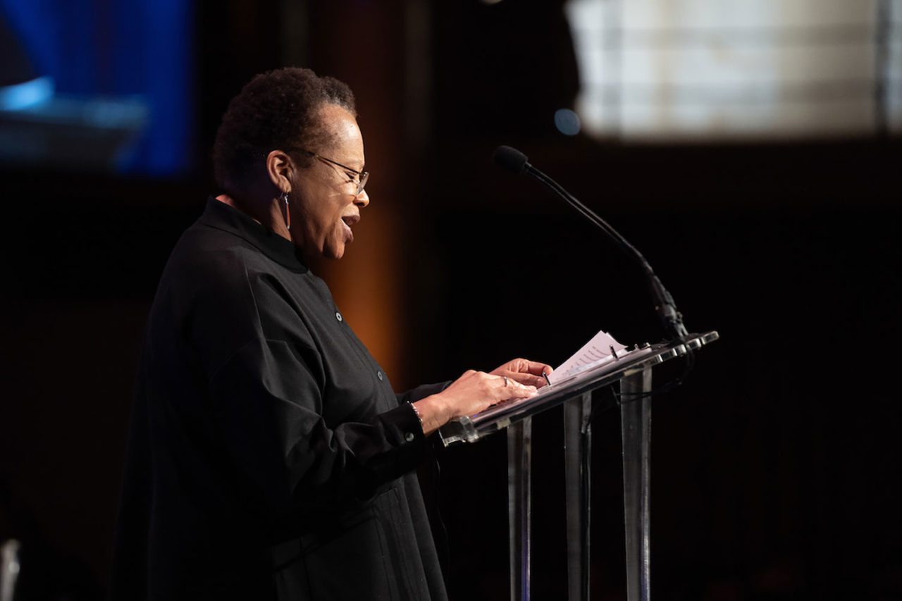 A woman stands at a podium.