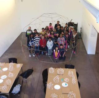 Students standing inside a geodesic dome