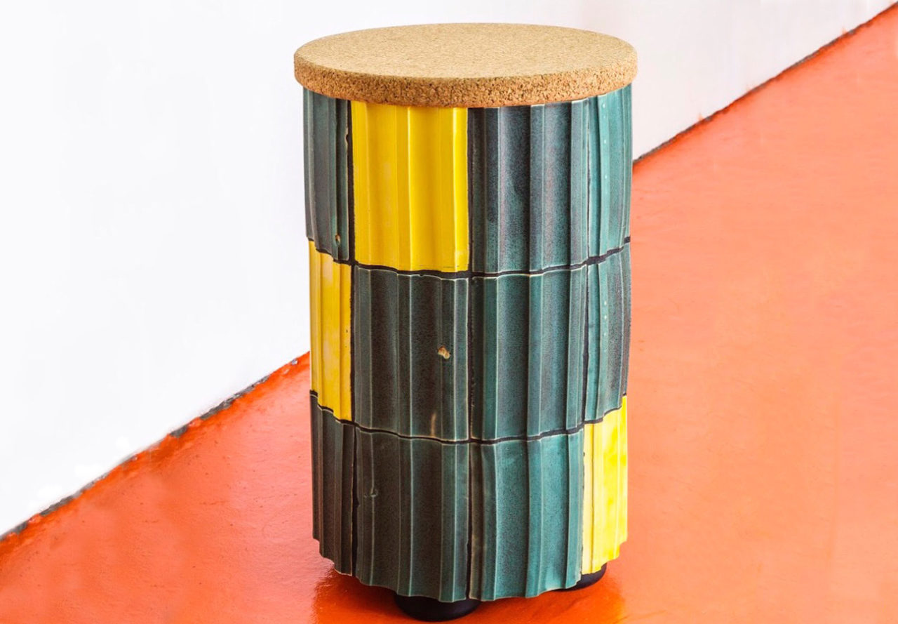 Cylindrical element clad in green and yellow fluted tiles