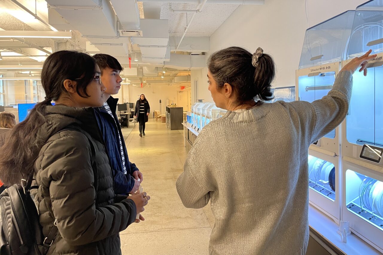Two high school students with architect on tour of office