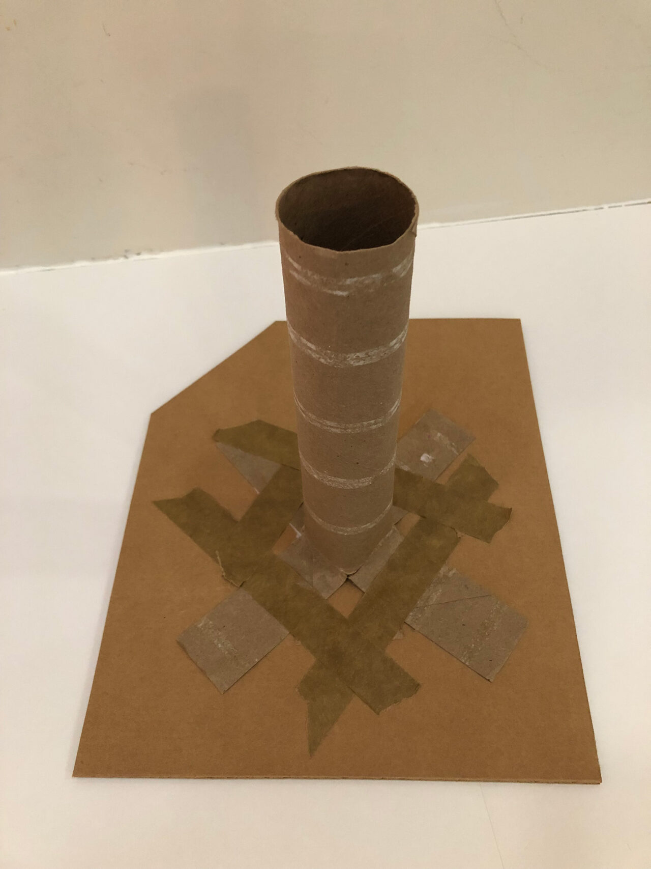 A cardboard tube taped onto a cardboard base.