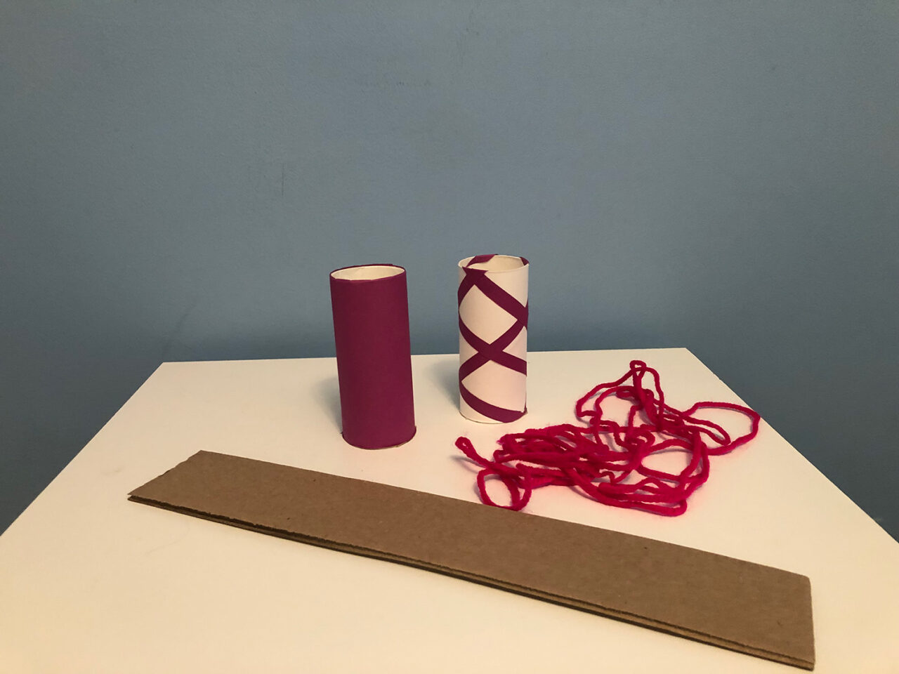 Materials for a model bridge: cardboard, string, toilet paper rolls