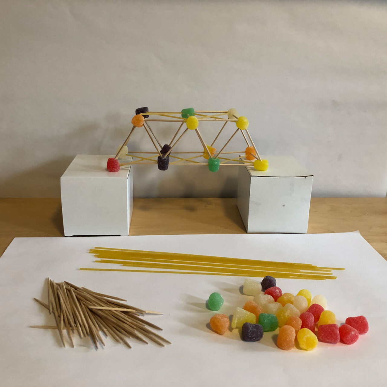 A truss bridge made of dried spaghetti, toothpicks, and gumdrops