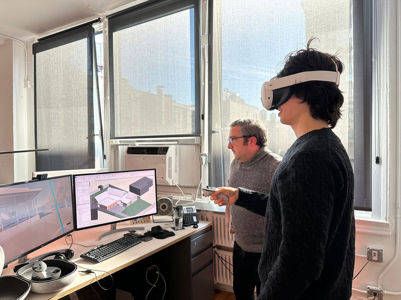 A student wearing AR googles interacts with several computer monitors