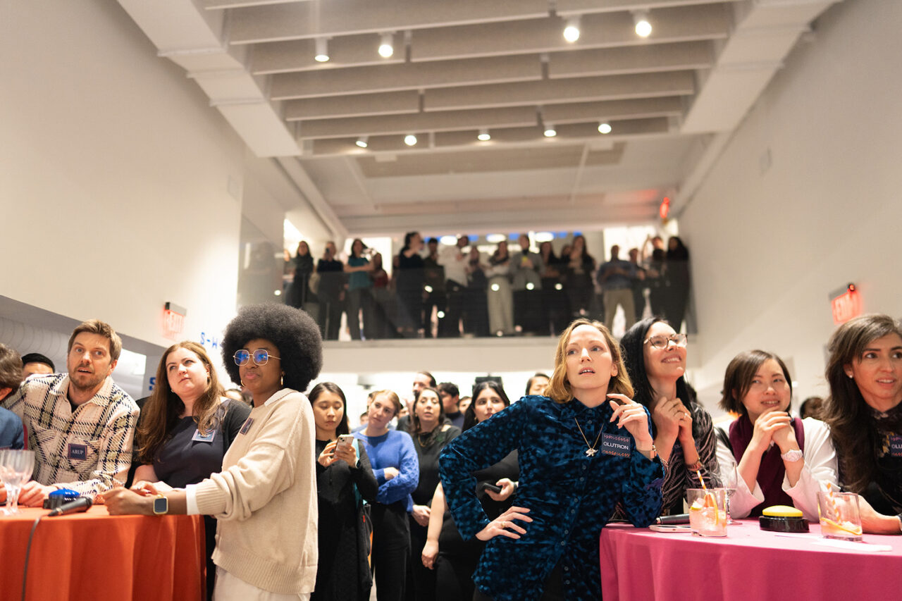 Competing teams at Guess-A-Sketch, with audience in the background.