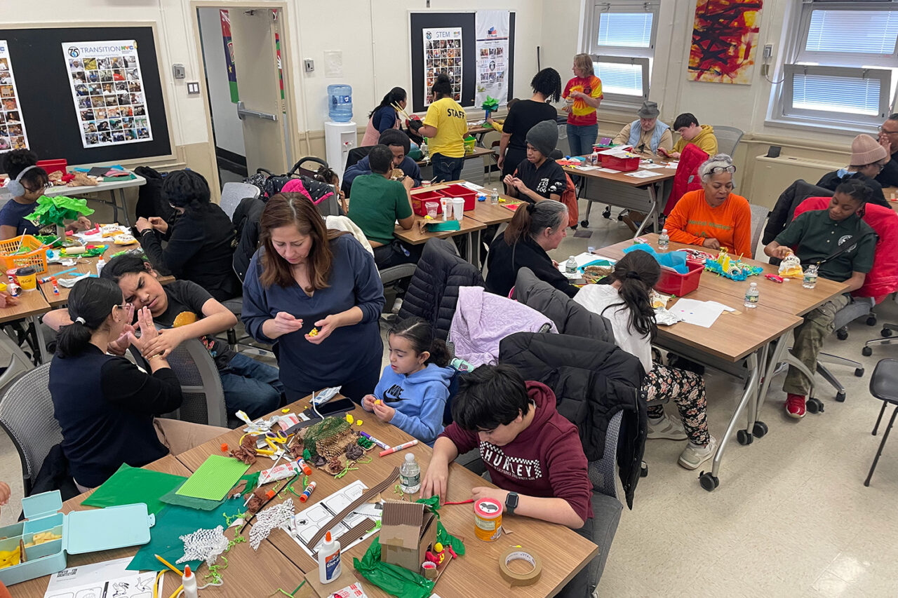 Kids and families work on architecture models in a classroom.