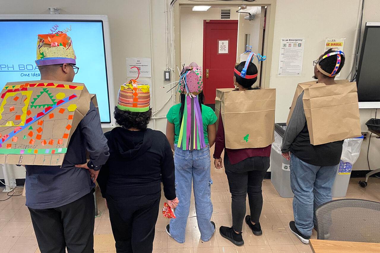 Kids pose, displaying the backs of their wearable architecture costumes.