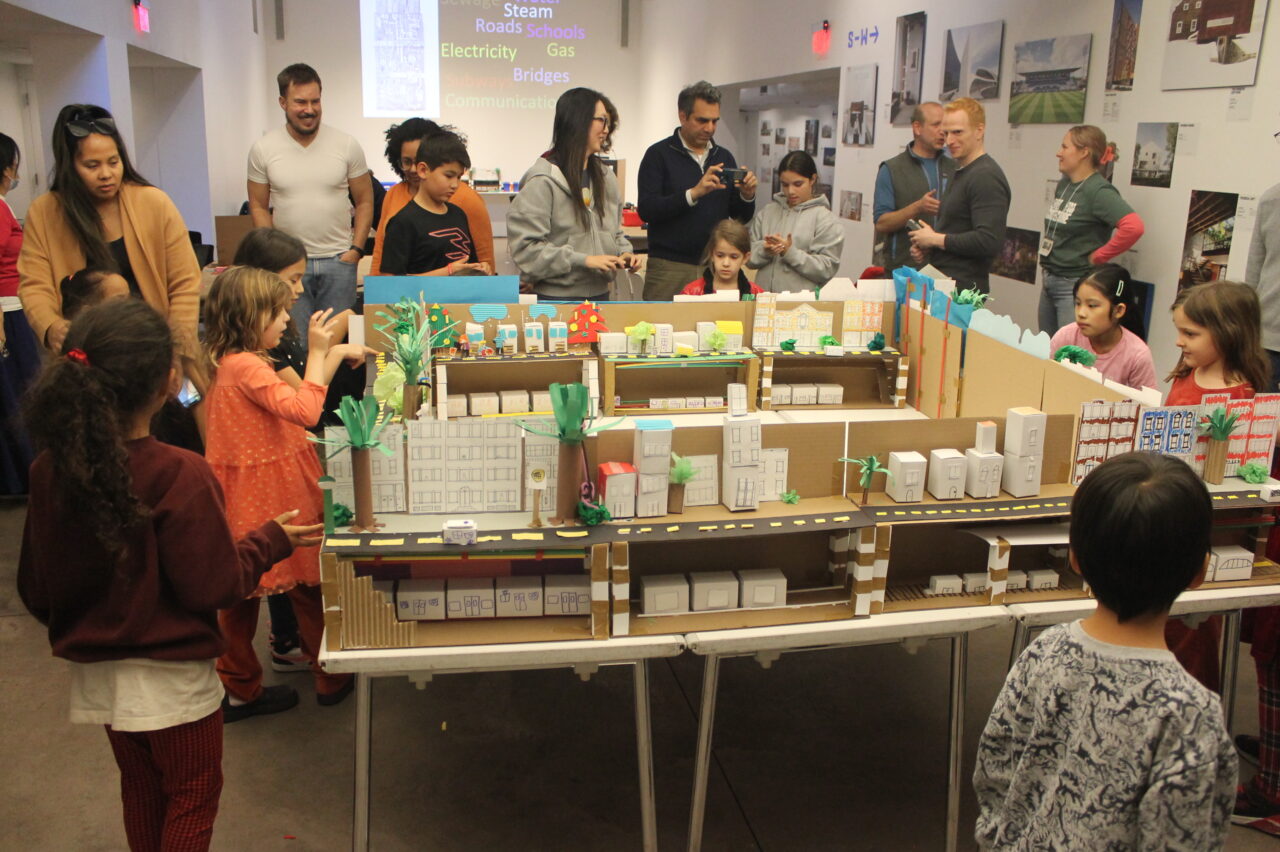 Families looking at model of NYC infrastructure.