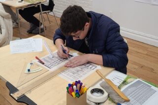 One high school student working on an elevation drawing using a pencil and t-square.
