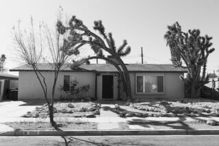 Black and white photo of a one-story house.