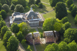 Birds eye view of a park with a two-story building with a round pavilion in front